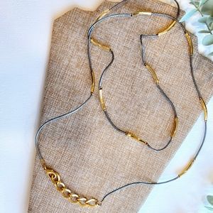 Long light and elegant string and gold tone tube designer necklace.